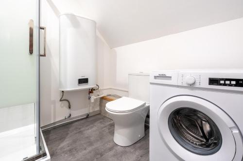 a white bathroom with a washing machine in it at Le Cocon Forestier - Proche aéroport Beauvais, Chantilly, forêt de Hez-Froidmont, parking public gratuit, Wifi & Netflix in Clermont