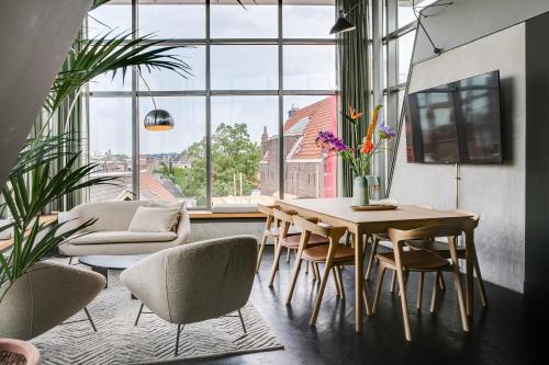 a dining room with a table and chairs and a large window at The Duke Boutique Hotel in Den Bosch
