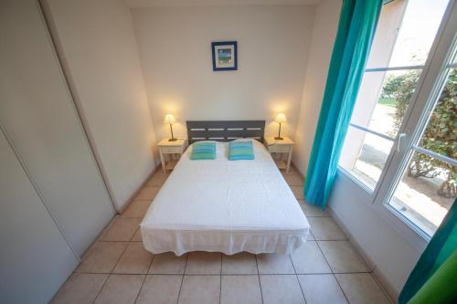 łóżko w pokoju z 2 oknami w obiekcie Résidence Belle Dune Blanche, maisons et appartements w mieście Biscarrosse-Plage