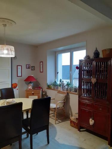 une salle à manger avec une table et une fenêtre dans l'établissement Petit nid des années 30 sur les hauts de Morlaix, à Morlaix