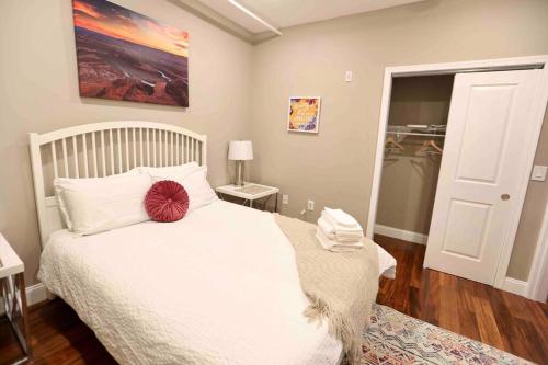 ein Schlafzimmer mit einem weißen Bett und einem roten Kissen darauf in der Unterkunft 504 Luxe 1BDR APT in center city in Philadelphia