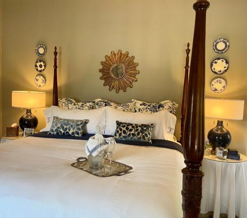 1 dormitorio con 1 cama grande con almohadas blancas y azules en Flowertown Bed and Breakfast en Summerville