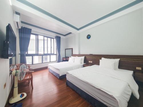 um quarto de hotel com duas camas e uma janela em Hùng Trang Hotel Tam Đảo 1 em Tam Dao