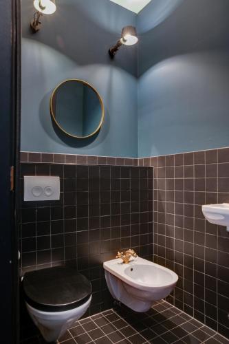 a bathroom with a toilet and a sink and a mirror at The Duke Boutique Hotel in Den Bosch