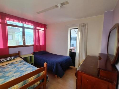 een slaapkamer met een bed, een spiegel en een raam bij FABRIZIO GUEST HOUSE in Cuzco