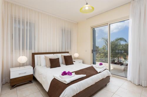 sypialnia z dużym łóżkiem i dużym oknem w obiekcie Villa Galina w mieście Neo Chorio