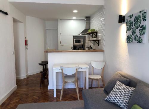 een woonkamer met een tafel en stoelen en een keuken bij NEW APARTMENT ON THE BEACH ( 100 METERS DISTANCE) in Cascais