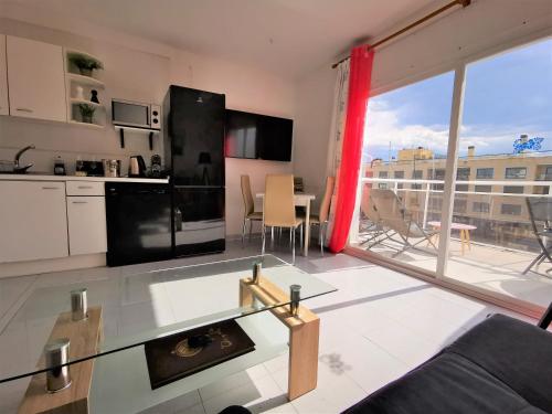 uma sala de estar com uma cozinha e uma grande janela em "Rooftop One" jacuzzi - plein sud - 2 chambres sur les canaux em Empuriabrava
