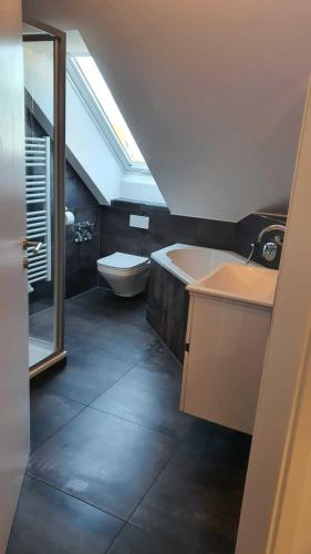a bathroom with a sink and a tub and a toilet at Modern Apartment near Munich Airport in Oberding