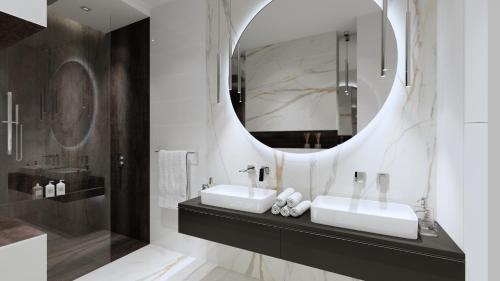 uma casa de banho com 2 lavatórios e um espelho em Biłgoraj Aparthotel em Bilgoraj