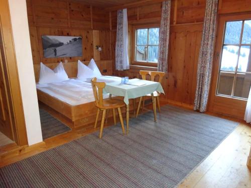 Schlafzimmer mit einem Bett, einem Tisch und Stühlen in der Unterkunft Landhaus Löberbauer in Tux