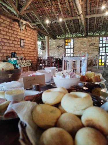 戈亚斯州科伦巴萨尔托科伦巴露营酒店的桌子上摆满了面包碗和食物碗。