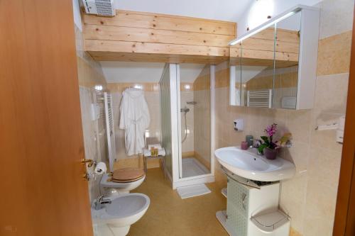 a bathroom with two toilets and a sink and a shower at Residence Panorama in Val di Zoldo