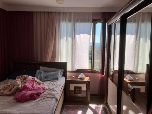 a small bedroom with a bed and a window at Önder suit in Rize