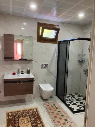 a bathroom with a shower and a toilet and a sink at Önder suit in Rize