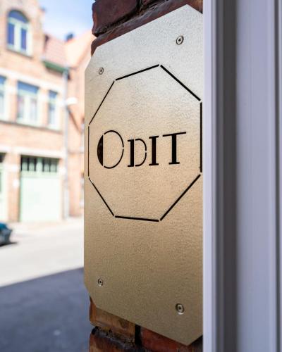 a sign on a brick wall with the word distort at Odit B&B in Bruges