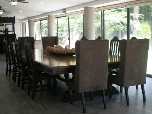 - une salle à manger avec une table et des chaises en bois dans l'établissement Hotel Camino del Bosque Atlixco by Rotamundos, à Atlixco