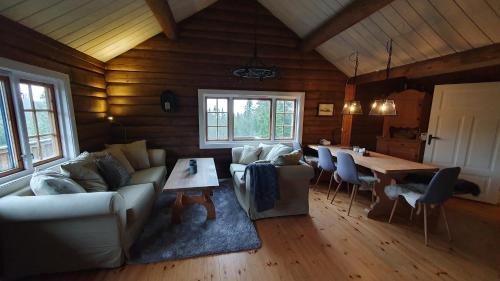 een woonkamer met een bank en een tafel bij Cozy log cabin at beautiful Nystølsfjellet in Gol