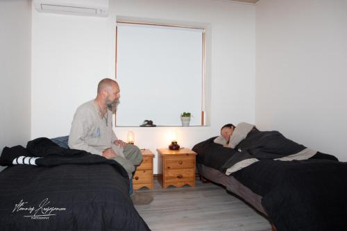two men sitting on beds in a room at VikingBnB in Kirke Såby