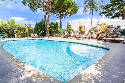 een zwembad met blauw water in een tuin bij Villa Reve & Piscine & Jacuzzi & Clim & Salle de musique in Nice