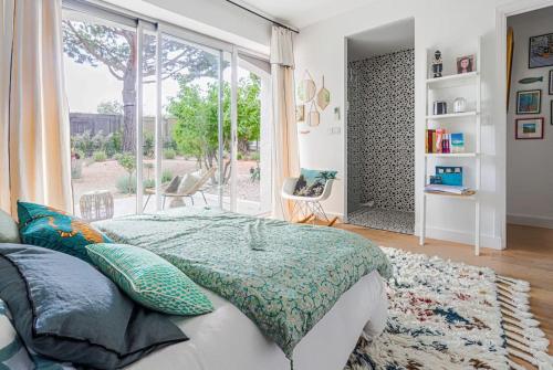een slaapkamer met een bed en een groot raam bij Villa Reve & Piscine & Jacuzzi & Clim & Salle de musique in Nice