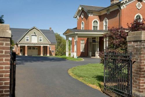 a brick house with a gate and a driveway at Best of My Love - CA King Size Bed+ - Sleeps 2-4 in Lynchburg