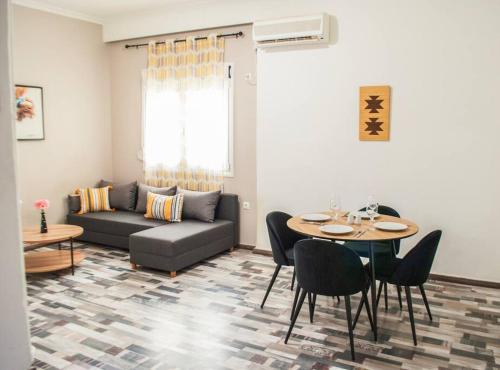 een woonkamer met een bank en een tafel en stoelen bij Your Athens Getaway: Stylish Apt in Athens in Athene