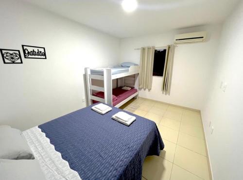 a small bedroom with a bed with a blue blanket at Apartamento Perto do Aeroporto in Lauro de Freitas