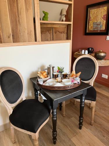 une table avec une assiette de nourriture et deux chaises dans l'établissement Les Nord’mandines, à Trouville-sur-Mer