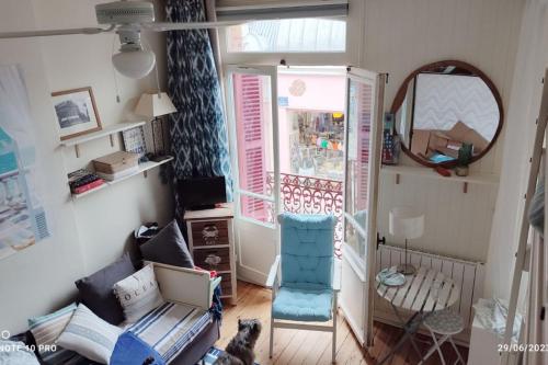 un salon avec une chaise bleue et un miroir dans l'établissement Cosy cocoon with 2 balconies and sea view, à Villers-sur-Mer