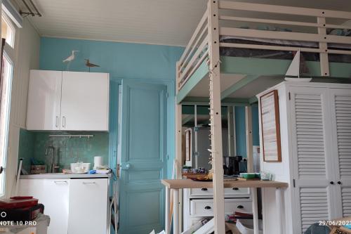 une cuisine avec des murs bleus et une échelle dans l'établissement Cosy cocoon with 2 balconies and sea view, à Villers-sur-Mer