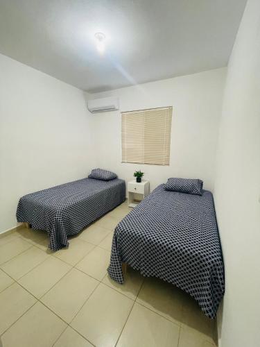1 dormitorio con 2 camas y ventana en Renta vacacional, en Playa del Carmen