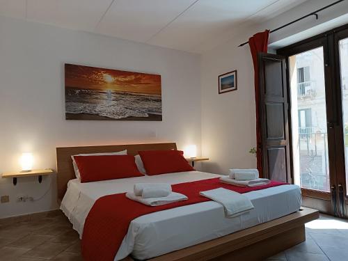 1 dormitorio con 1 cama grande con almohadas rojas en Le Rose di Maria, en Trapani