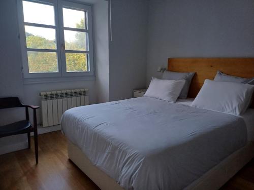 エリソンドにあるAritza Apartamentos Turísticos Ruralesのベッドルーム(大きな白いベッド1台、窓付)