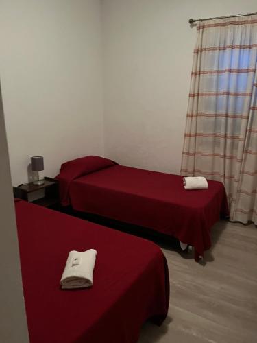 two beds in a room with red sheets at Miradouro da Serra in Monchique