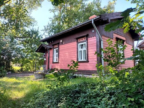 stary czerwony dom pośrodku pola w obiekcie Sallimeister Linda külalistemaja. w mieście Haapsalu