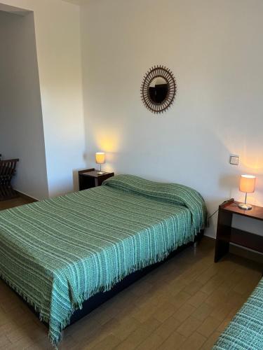 a bedroom with a green bed with two tables and a mirror at Miradouro da Serra in Monchique