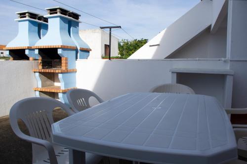 ヴィラ・ノヴァ・デ・ミルフォンテスにあるApartamentos Monte da Rosaの青いテーブルと椅子が備わるパティオ