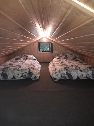 2 Betten in einem kleinen Zimmer mit Fenster in der Unterkunft Domki letniskowe Jastrzębna in Sztabin