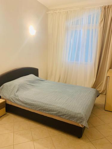 a bed in a room with a window and a bedvisor at Райское место in Šušanj
