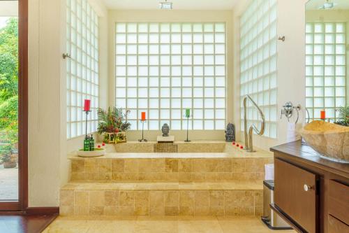 a large bathroom with a tub and a large window at Colores del Viento in Uvita