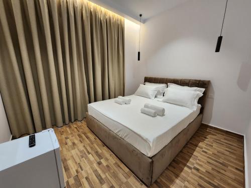 1 dormitorio con 1 cama con sábanas y almohadas blancas en Sea Front Villa, en Vlorë