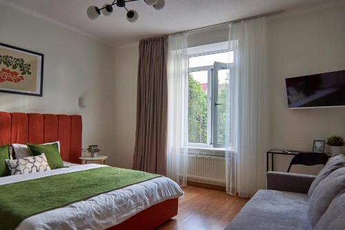 a bedroom with a large bed and a window at Best Apartments on Kyryla & Mefodia in Mukacheve