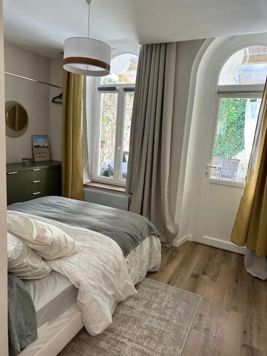 une chambre avec un lit et deux fenêtres dans l'établissement Appartement cosy avec jardin proche de la gare, à Boulogne-sur-Mer