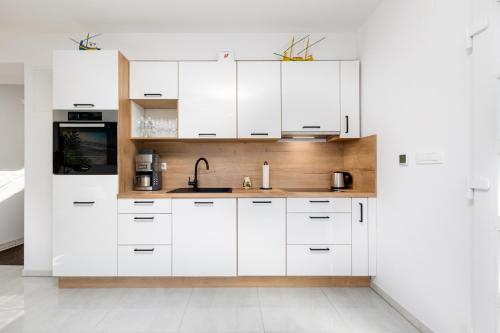 克爾克的住宿－Apartment Kamila，白色的厨房配有白色橱柜和水槽