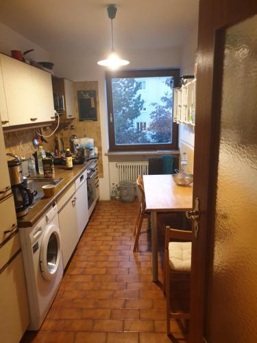 ミュンヘンにあるOktoberfestのキッチン(洗濯機、テーブル付)、窓が備わります。