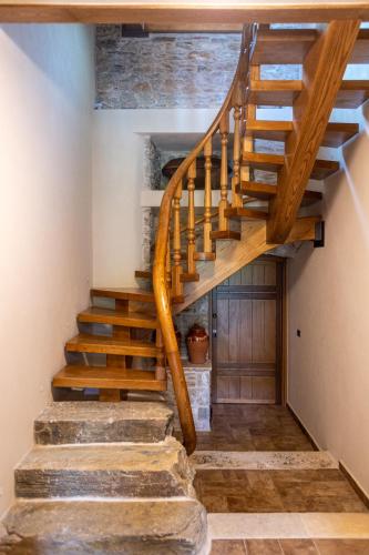 a wooden staircase in a house with a wooden door at Nostos Country House in Tsagarada