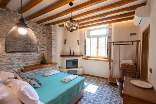a bedroom with a blue bed and a fireplace at Nostos Country House in Tsagarada