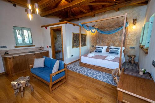 a bedroom with a canopy bed and a blue chair at Nostos Country House in Tsagarada