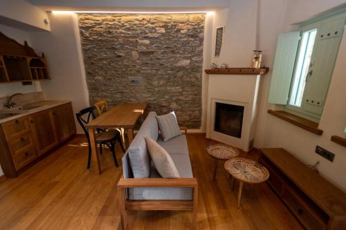 a living room with a couch and a fireplace at Nostos Country House in Tsagarada